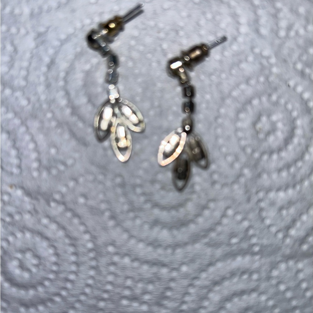 Women’s white metal earrings with small glass-like stones.